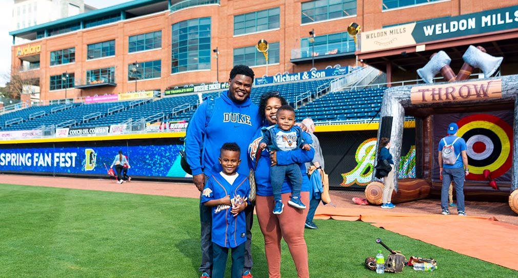 Photo of a family standing on the Durham Bulls ball field